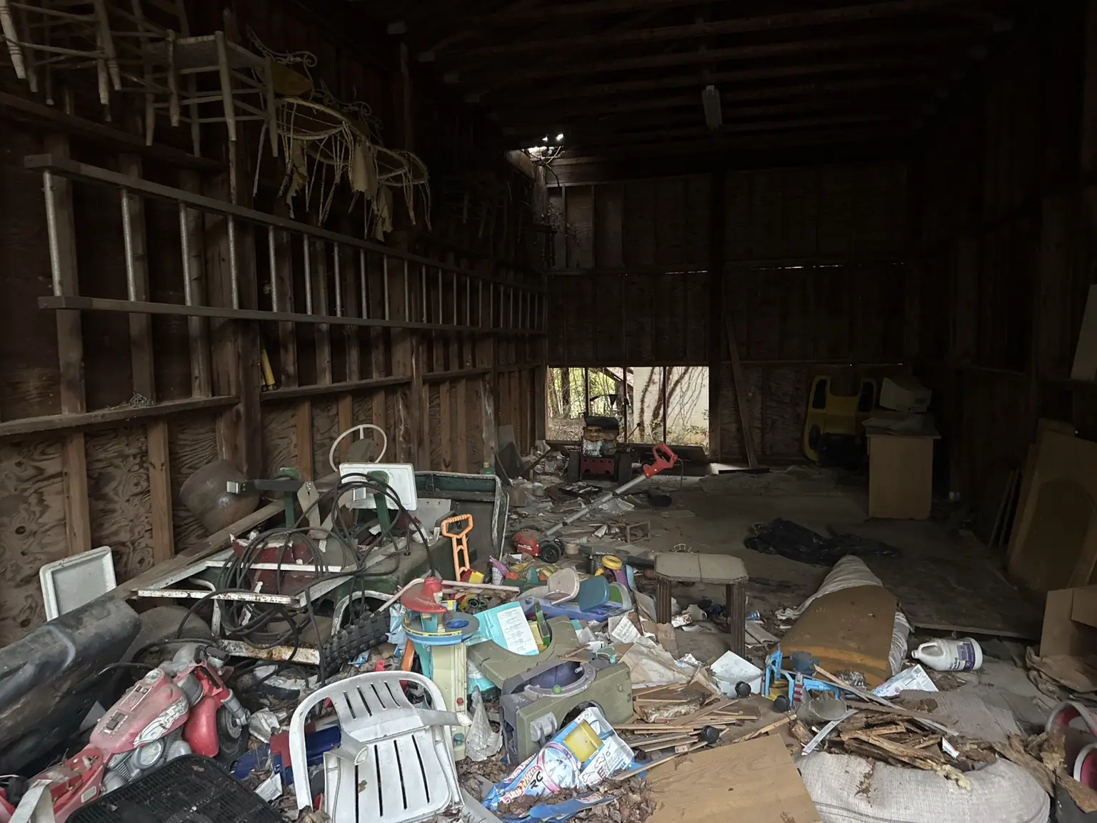 Cluttered outbuilding interior before a property cleanout