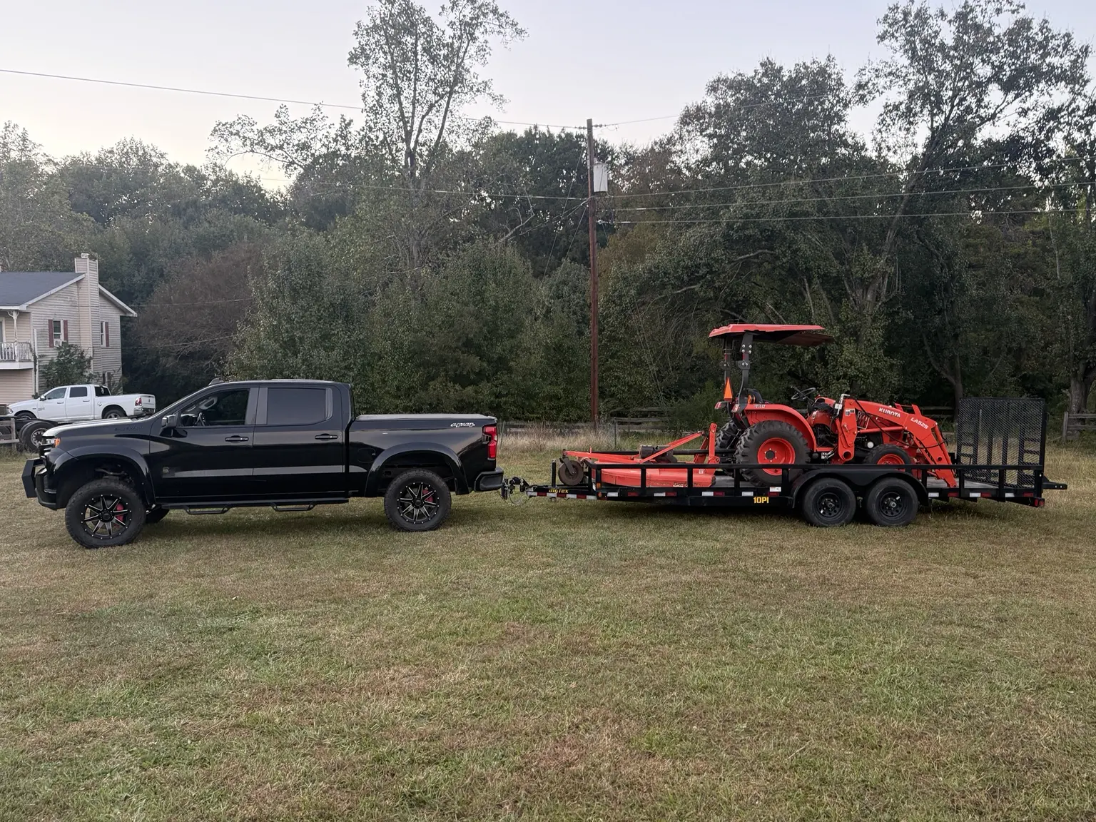 Red Drum truck, tractor and equipment trailer staged for property work